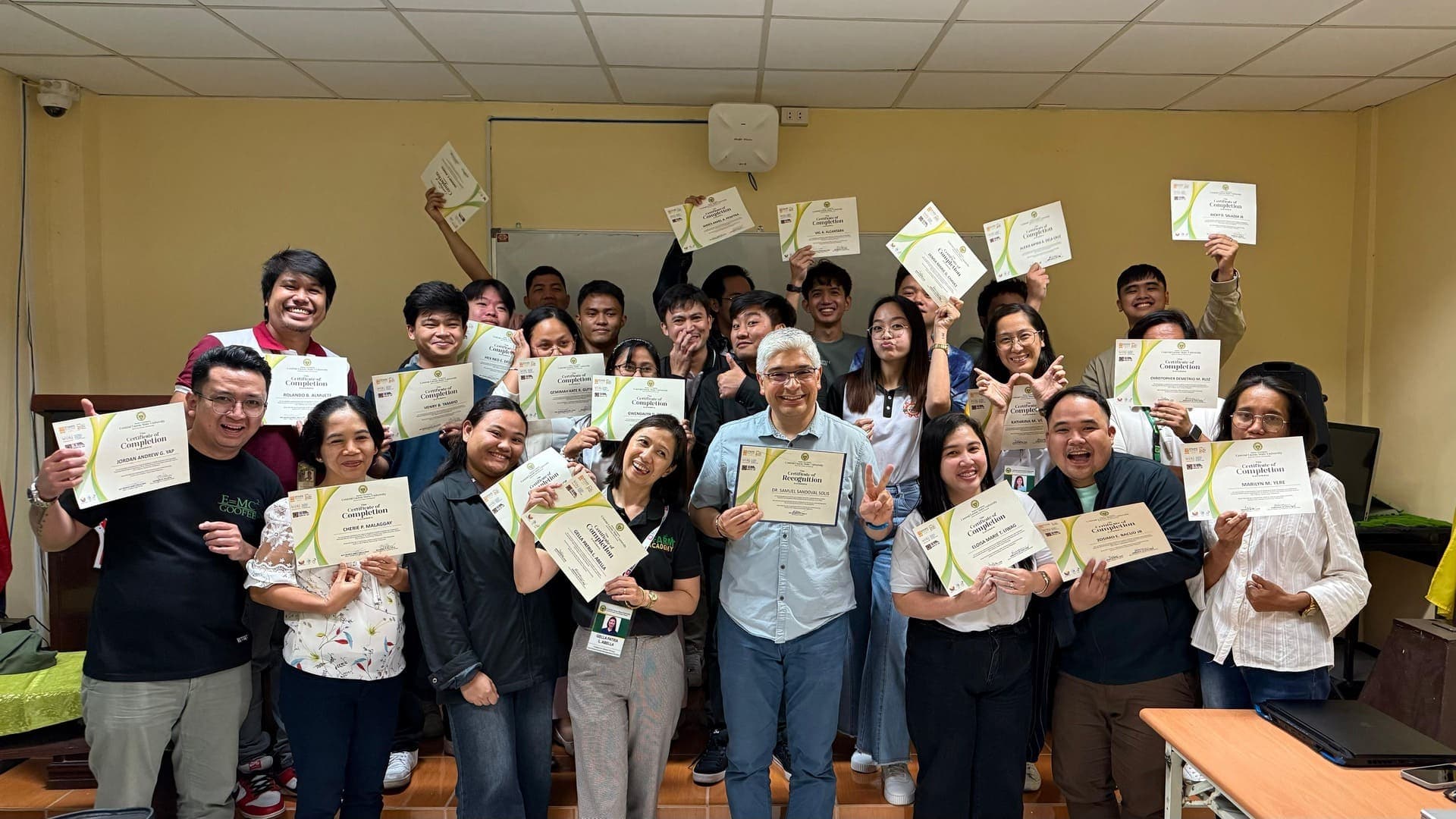 Workshop participants hold certificates of completion beside volunteer Dr. Samuel Sandoval Solis at Central Luzon State University, Philippines